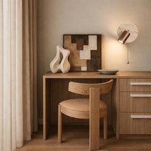 Brim Travertine wall light with brass pull cord, illuminating a modern wooden desk and chair.