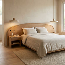 Two Kaia natural stone and oak pendant lights illuminate a minimalist bedroom.