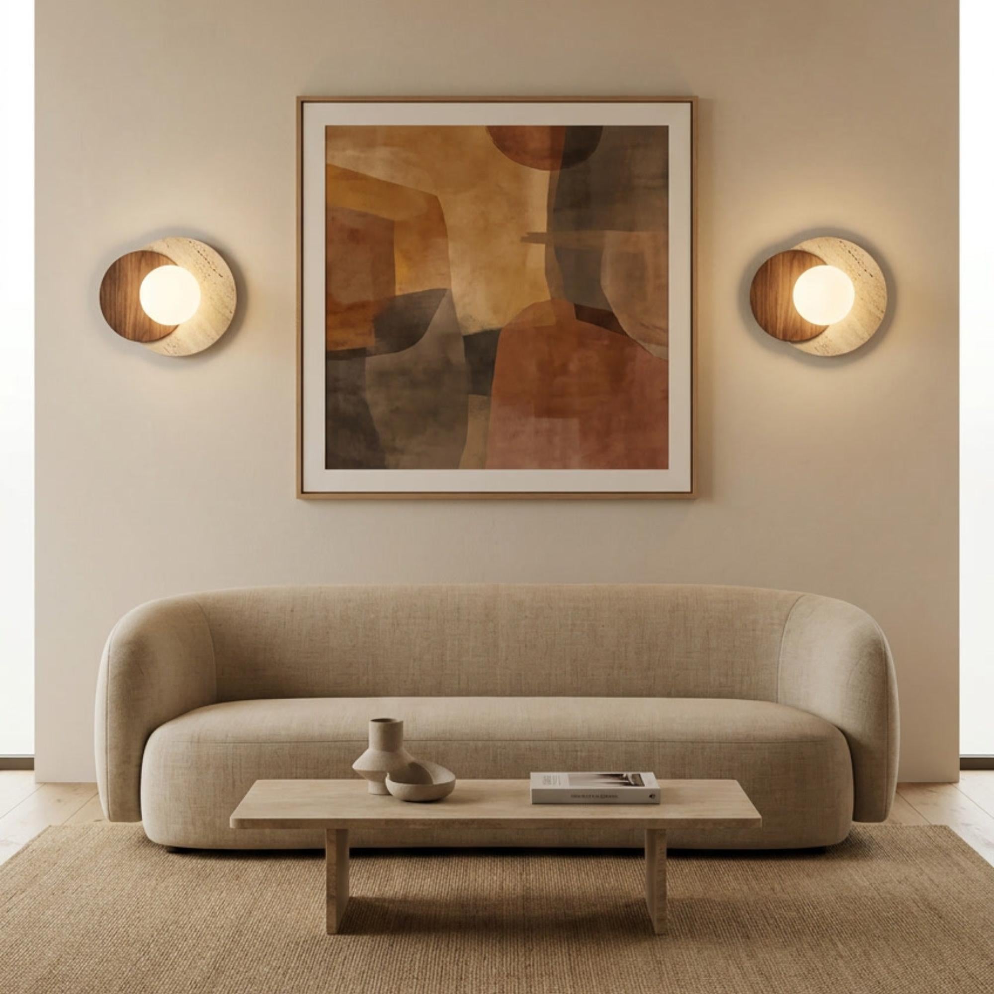 Lyra Natural Stone & Wood Wall Sconce with opal glass orb, flanking abstract art above a beige sofa.