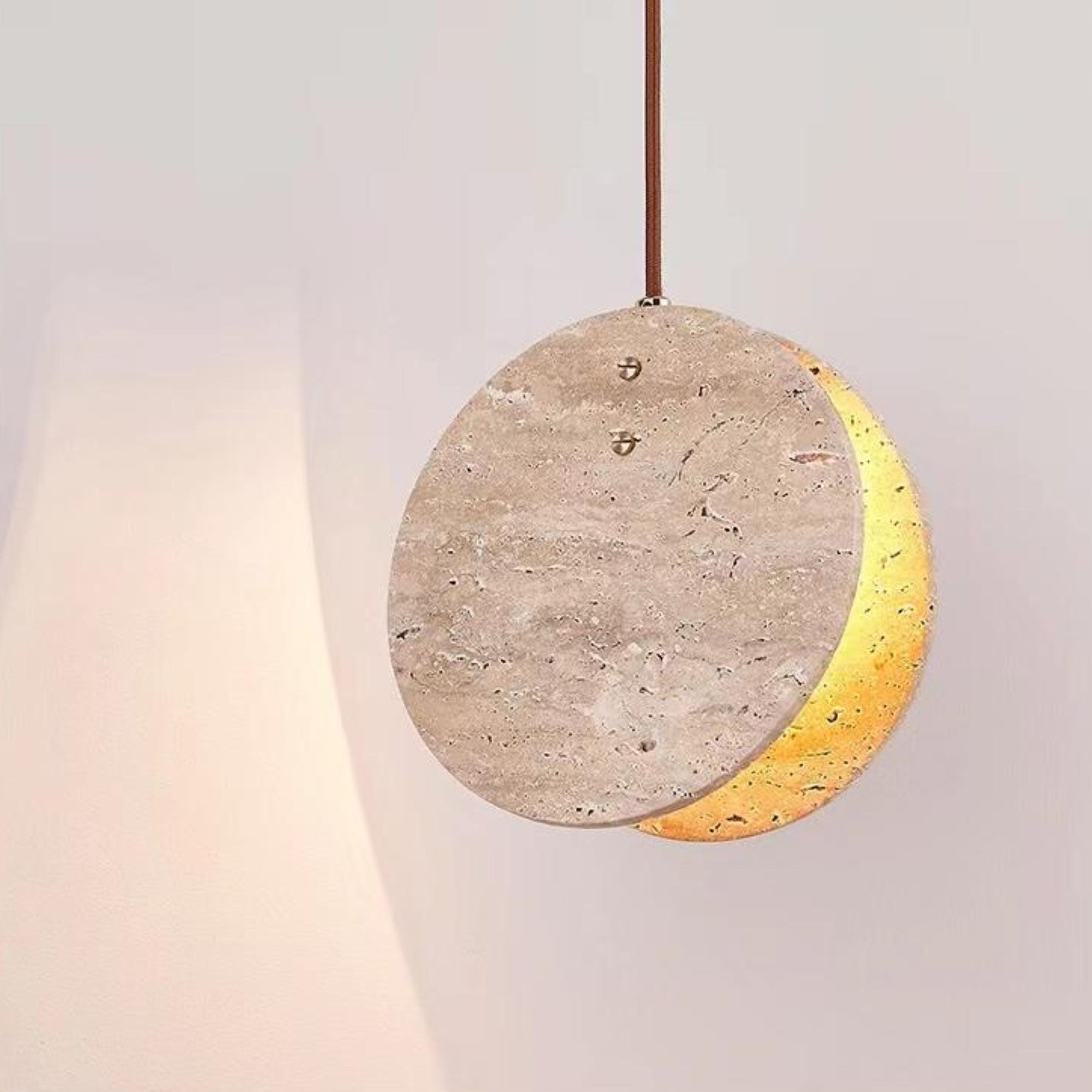 Modern Nacre Travertine Pendant Light, a round stone fixture with warm glow and brown cord.