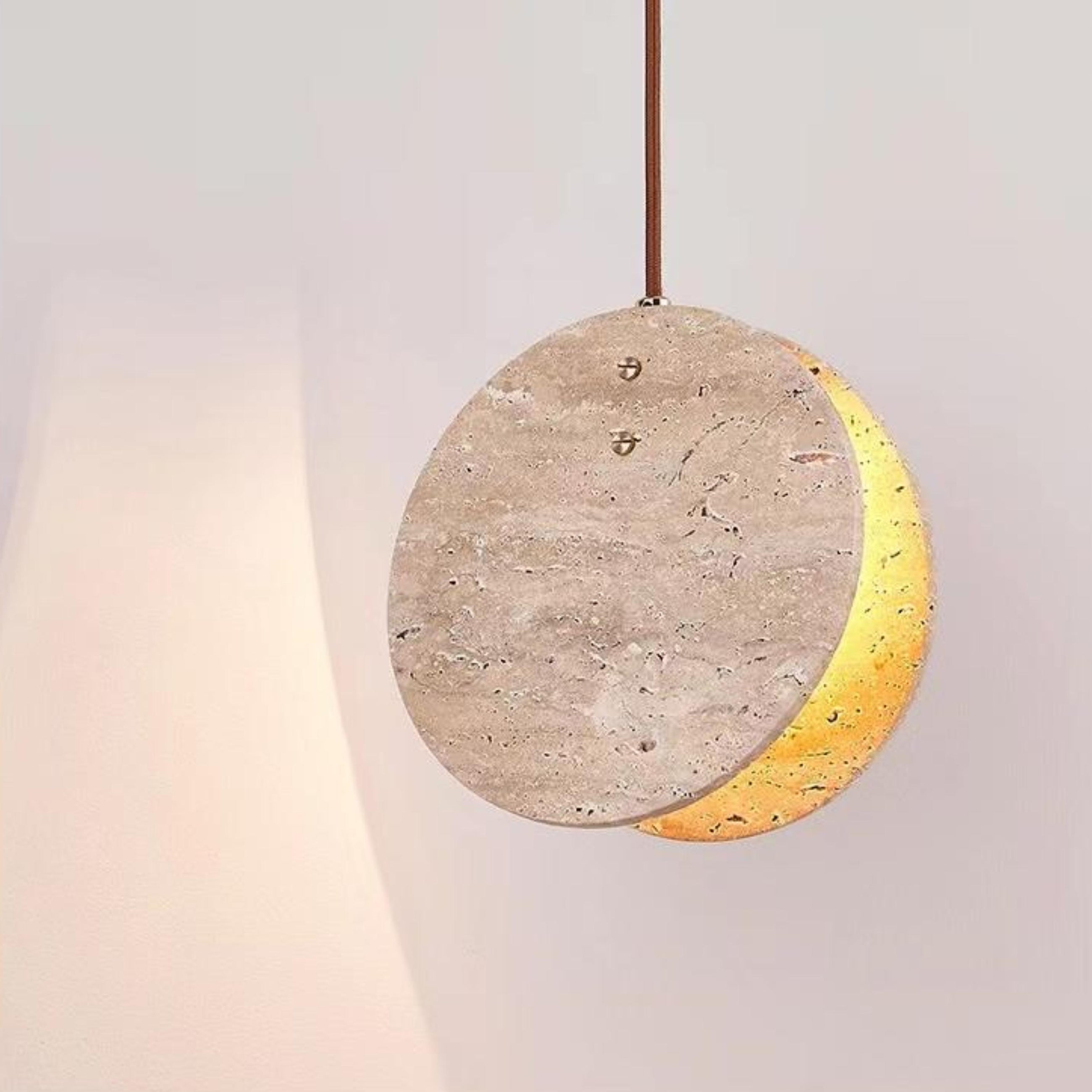 Modern Nacre Travertine Pendant Light, a round stone fixture with warm glow and brown cord.