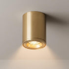Nero solid brass LED surface mounted downlight with a honeycomb lens, emitting warm light.